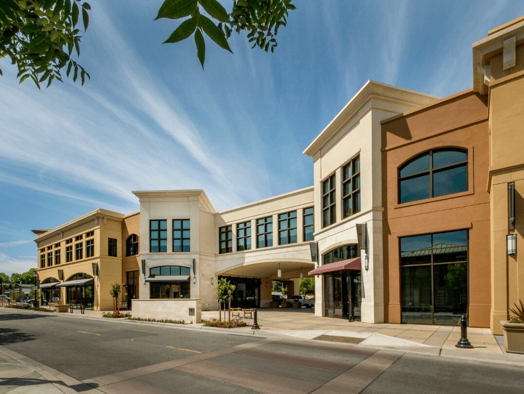 Modern two-story commercial retail and office building under a clear blue sky