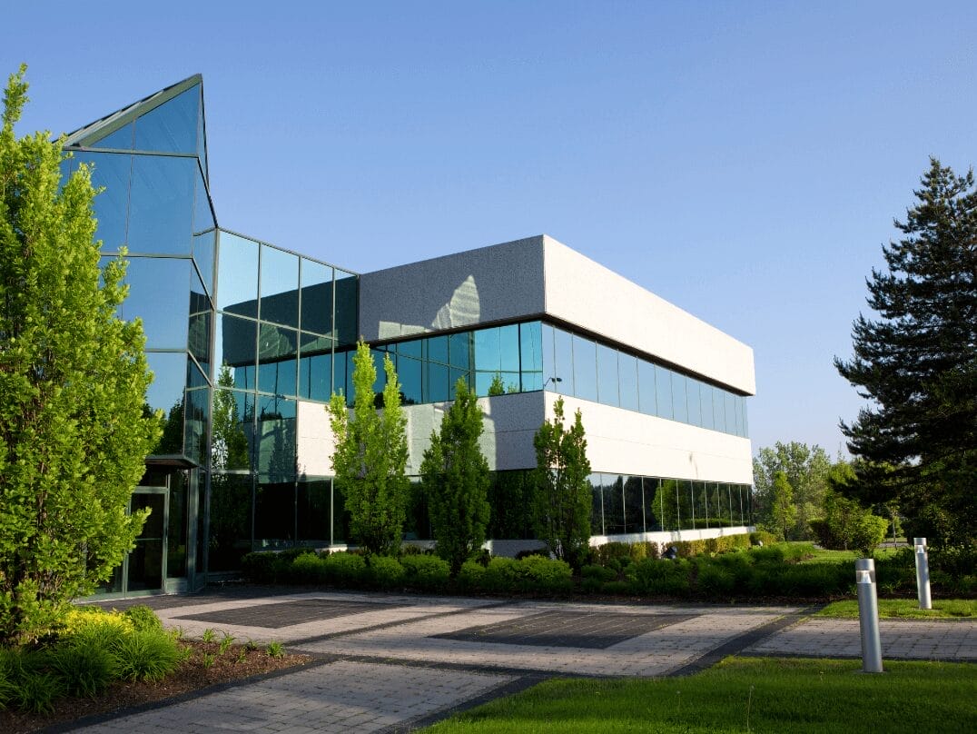 Modern commercial office building with glass façade and landscaped surroundings
